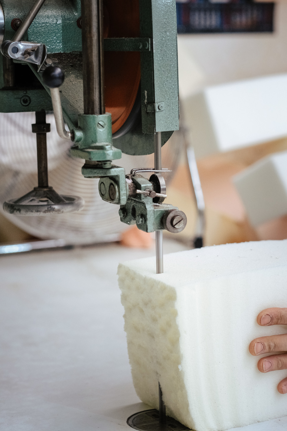 Plano vertical de un fabricante de muebles cortando una espuma de tapicería